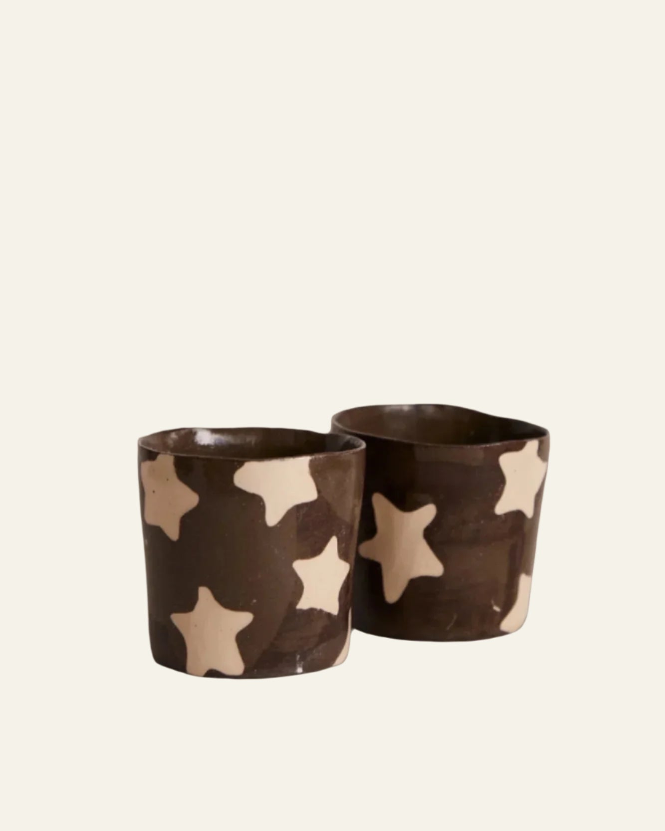 Two brown ceramic cups with beige star patterns